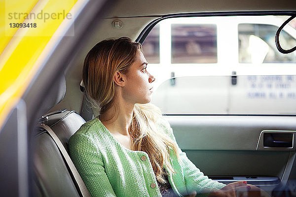 Porträt einer Frau  die in der Stadt im Taxi sitzt