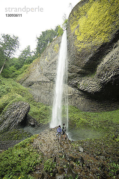 Hochwinkelansicht des Paares beim Blick auf den Wasserfall