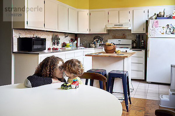 Mutter spielt mit ihrem Sohn zu Hause in der Küche