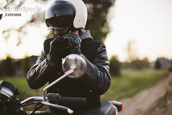 Verstellbarer Helm für männliche Motorradfahrer auf dem Motorrad sitzend