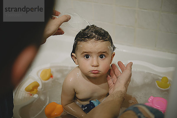 Hochwinkelaufnahme eines Vaters  der seine Tochter zu Hause in der Badewanne badet
