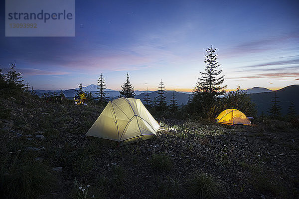 Beleuchtete Zelte auf dem Feld gegen den Himmel bei Sonnenuntergang