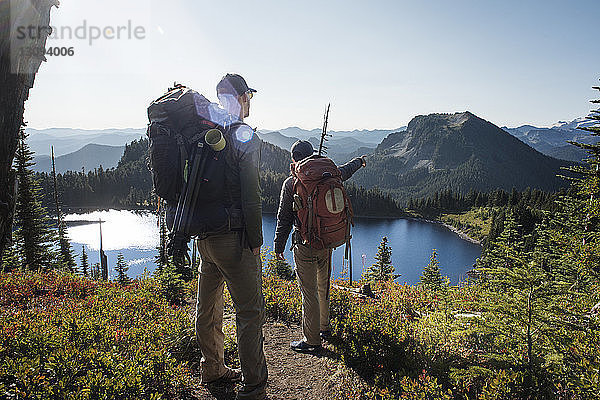 Männliche Freunde wandern auf Berg gegen See