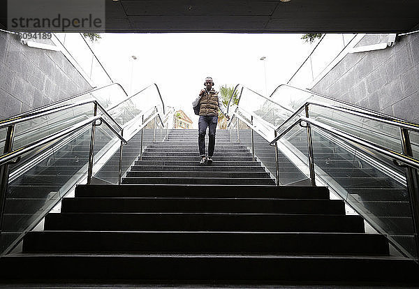 Mann in voller Länge auf den Stufen der U-Bahn-Station