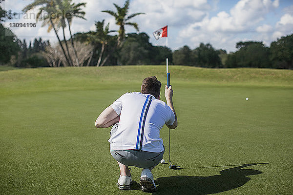 Rückansicht eines Mannes im Fokus auf einem Golfplatz
