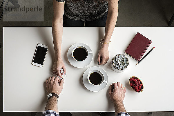 Draufsicht auf ein Paar mit Kaffee am Tisch im Café