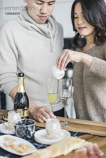 Frau mit Freund trinkt am Tisch in der Küche