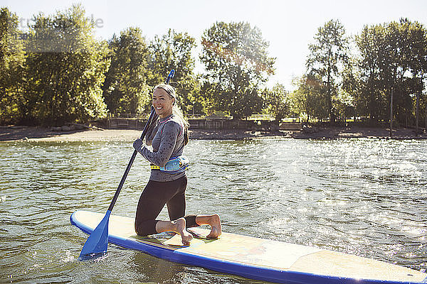 Porträt einer lächelnden Frau beim Paddelbootfahren auf einem Fluss