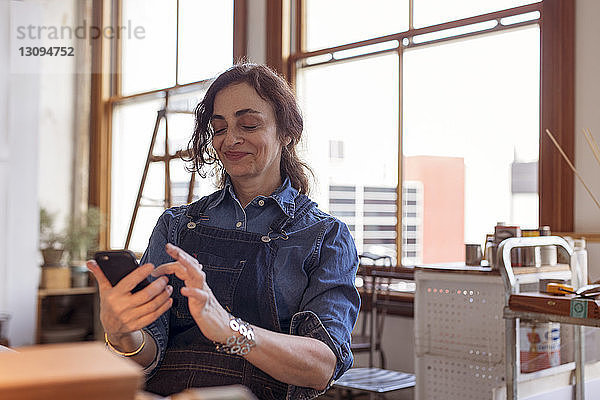 Künstlerin benutzt Mobiltelefon in Workshop