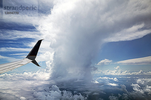 Ausschnittsbild eines Flugzeugs bei bewölktem Himmel