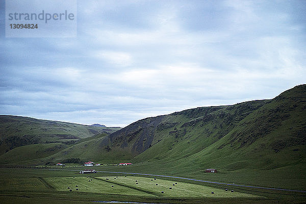 Szenische Ansicht einer grünen Landschaft vor bewölktem Himmel in der Dämmerung