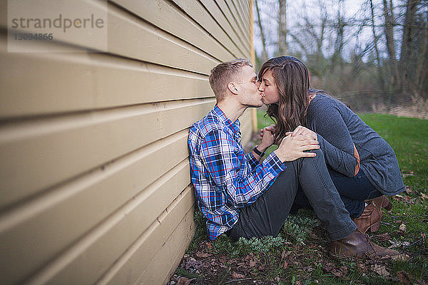Seitenansicht eines sich küssenden Paares im Hinterhof