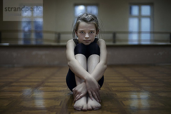 Porträt eines selbstbewussten Mädchens  das im Tanzstudio sitzt