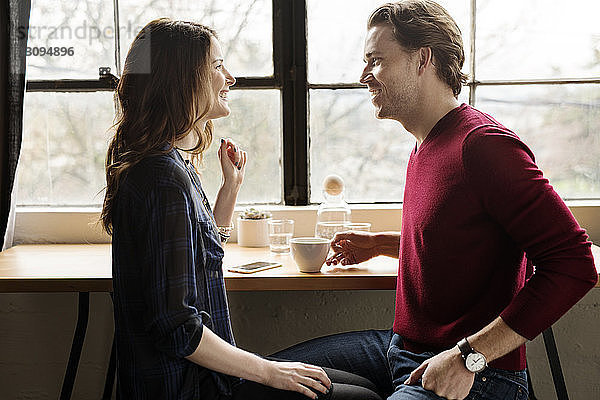 Glückliches Paar schaut sich im Café von Angesicht zu Angesicht
