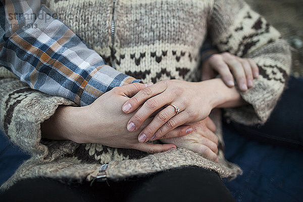 Abgehackte Hand des Freundes auf dem Bauch der Freundin