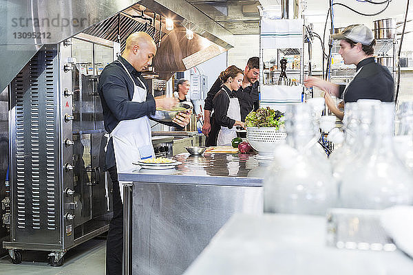 Köche  die in der Großküche eines Restaurants Speisen zubereiten