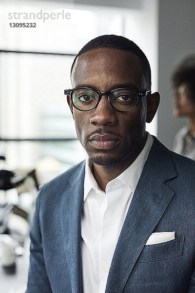 Porträt eines selbstbewussten Geschäftsmannes  der im Büro eine Brille trägt
