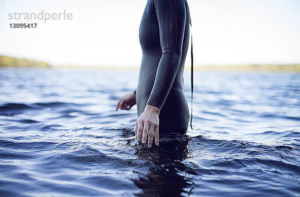 Seitenansicht Mittenansicht einer im See stehenden Schwimmerin