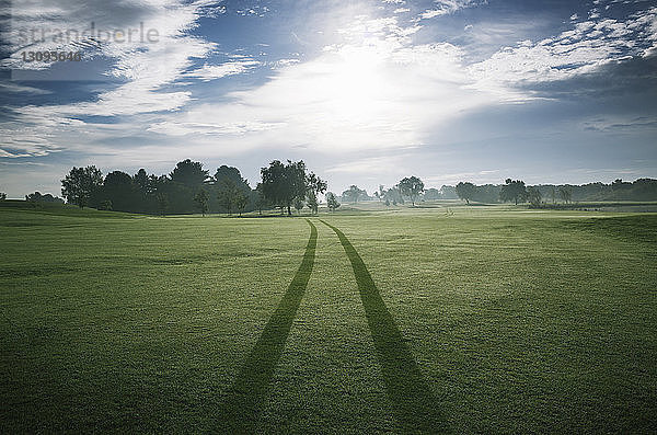 Reifenspuren auf dem Golfplatz gegen den Himmel an einem sonnigen Tag
