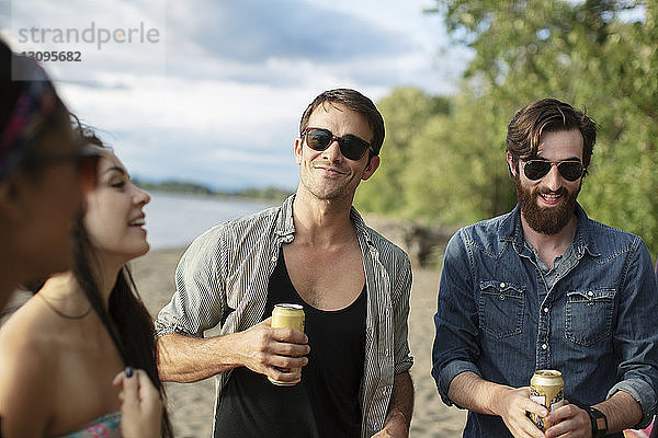 Glückliche Freunde bei einem Drink am Flussufer