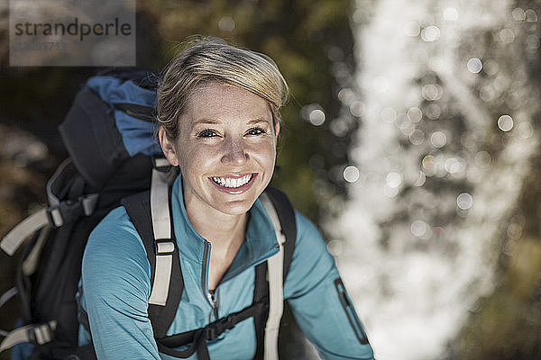 Porträt einer fröhlichen Wanderin mit Rucksack