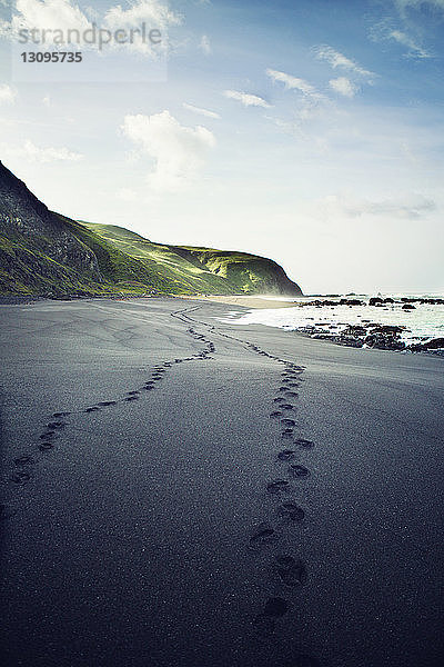 Fußabdrücke am Strand gegen den Himmel