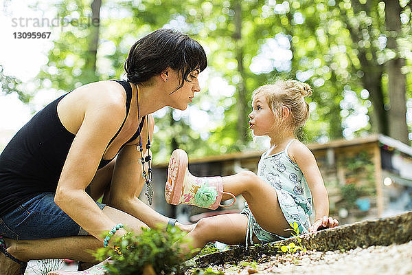 Seitenansicht der Mutter im Gespräch mit der Tochter im Hinterhof