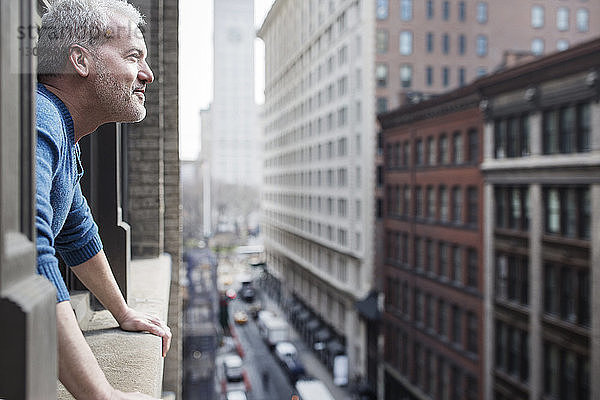 Seitenansicht eines Mannes  der durch ein Fenster auf Gebäude schaut