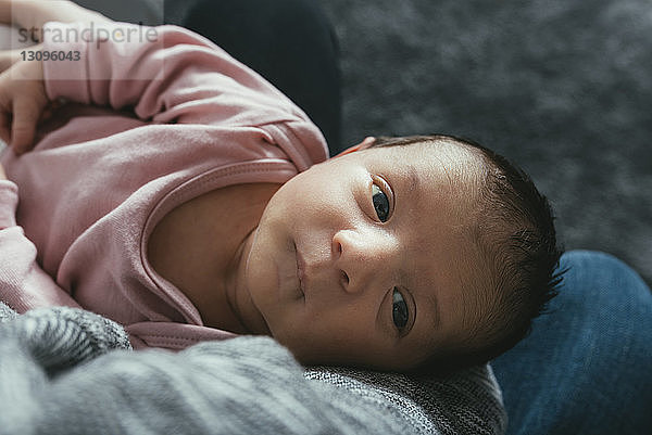 Hochwinkelansicht eines süßen Mädchens  das von der Mutter zu Hause getragen wird