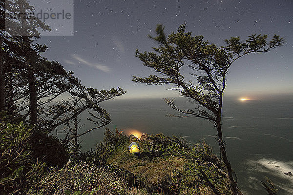 Hochwinkelansicht von Zelten auf einem Berg am Meer bei Nacht