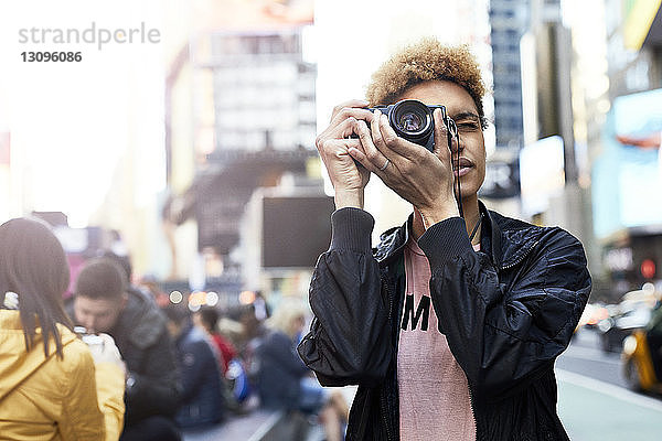 Junge Frau fotografiert durch Digitalkamera in der Stadt