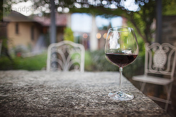 Ein Glas Rotwein auf dem Tisch im Hof