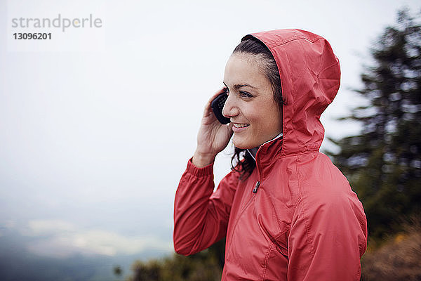 Glückliche Wanderin im Telefongespräch