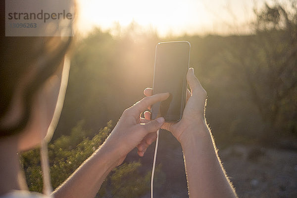 Ausgeschnittenes Bild einer Frau bei der Benutzung eines Mobiltelefons