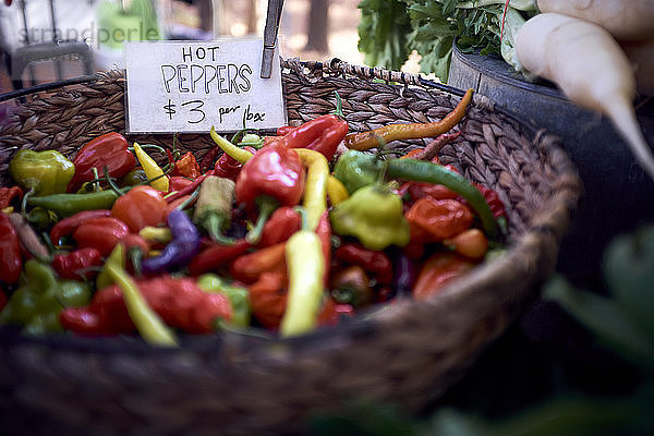 Hochwinkelansicht von Chilischoten zum Verkauf im Weidenkorb am Marktstand