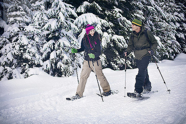 Paar Schneeschuhwandern im Wald