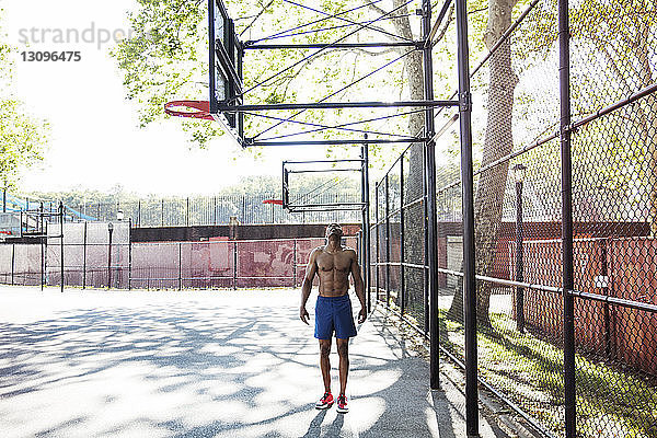 Mann schaut auf  während er im Basketballfeld steht