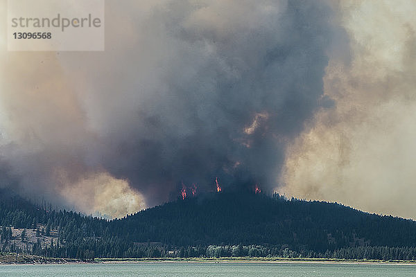 Rauch  der während eines Waldbrandes im Grand-Teton-Nationalpark aus den Bergen aufsteigt
