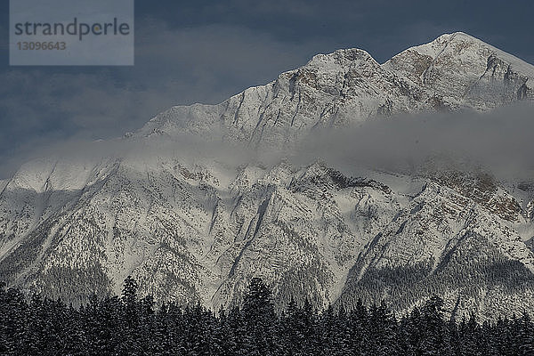 Idyllischer Blick auf schneebedeckte Berge inmitten von Wolken