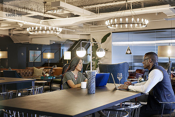 Geschäftsleute  die Laptop-Computer benutzen  während sie im Kreativbüro sitzen