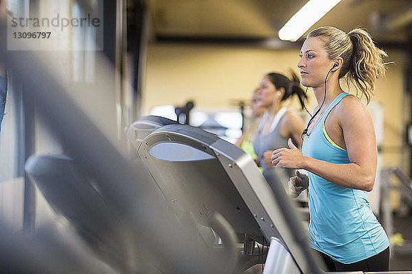 Frauen trainieren auf Laufbändern im Fitnessstudio