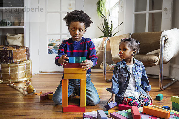 Junge und Mädchen spielen zu Hause mit Spielzeugklötzen
