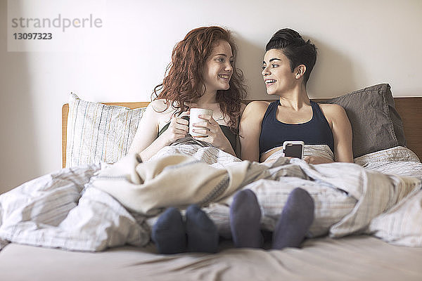 Glückliches lesbisches Paar  das sich gegenseitig im Bett ansieht