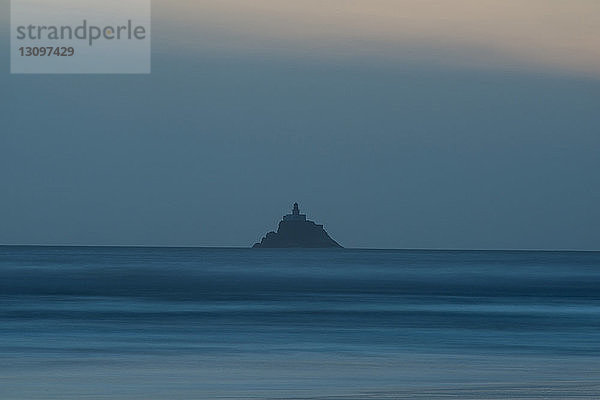 Silhouetten-Leuchtturm auf einem Berg in Tillamook Island gegen den Himmel in der Abenddämmerung