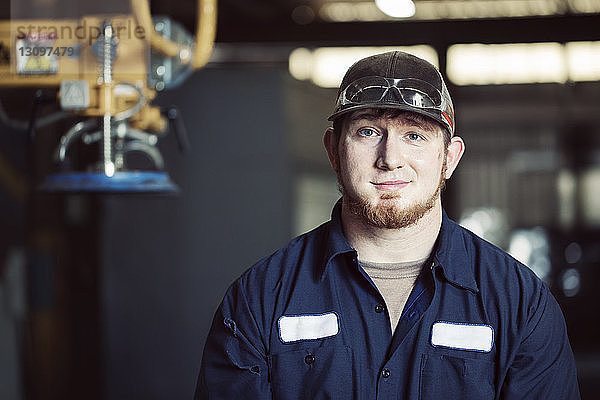 Porträt eines selbstbewussten Arbeiters mit Mütze in einer Stahlfabrik