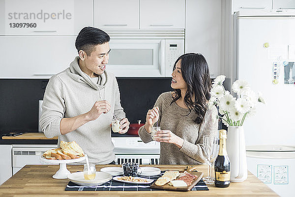 Glückliches Paar sieht sich beim Frühstück in der Küche an