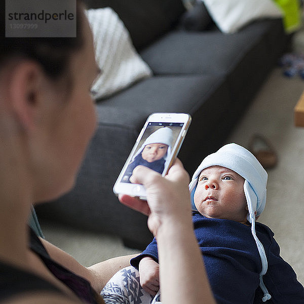 Mutter fotografiert Sohn über Mobiltelefon zu Hause
