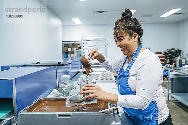 Seitenansicht einer Bäckerei  die Schokolade in einem schuhförmigen Behälter in der Fabrik füllt