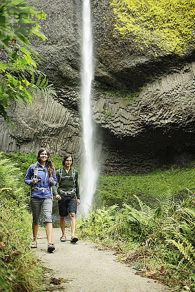 Paar auf Wanderweg am Wasserfall im Wald