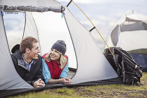 Glückliches Paar entspannt sich im Zelt auf dem Campingplatz
